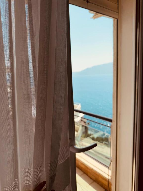 a sliding glass door with a view of the ocean at The Blue Horizon in Vlorë
