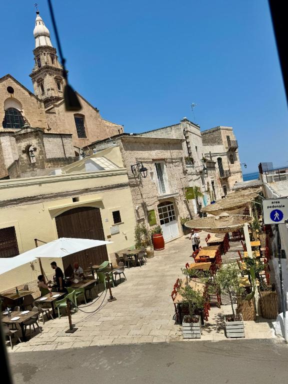 a courtyard with tables and chairs and a building with a tower at Dimora Marina in Monopoli