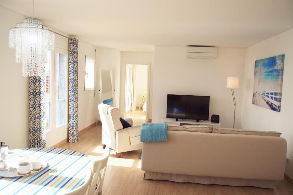- un salon avec un canapé et une télévision dans l'établissement Barbadinhos Apartment, à Lisbonne