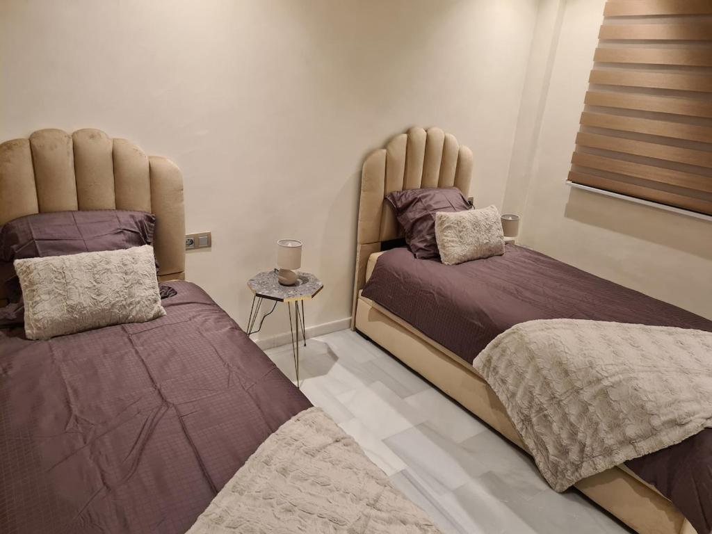 deux lits côte à côte dans une chambre dans l'établissement Appartement sur la corniche 2 chambres, à Tanger