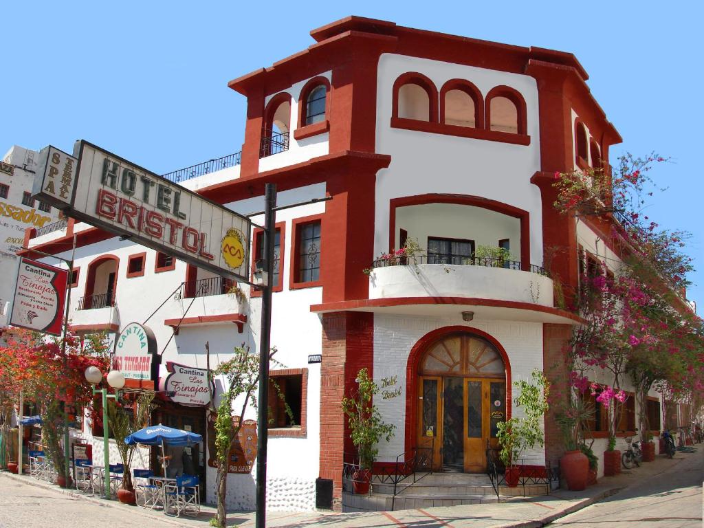 un bâtiment rouge et blanc au coin d'une rue dans l'établissement Hotel Bristol, à Termas de Río Hondo