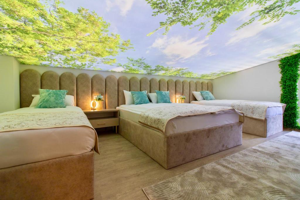 two beds in a room with a ceiling at Monti Wellness & Spa Vlašić in Vlasic