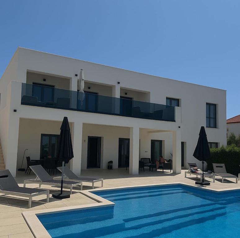 a villa with a swimming pool in front of a house at Villa Gala in Trogir