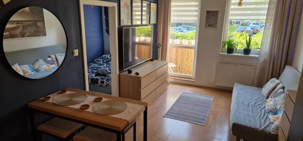 a living room with a table and a mirror at Apartament Morze i Rekiny in Reda