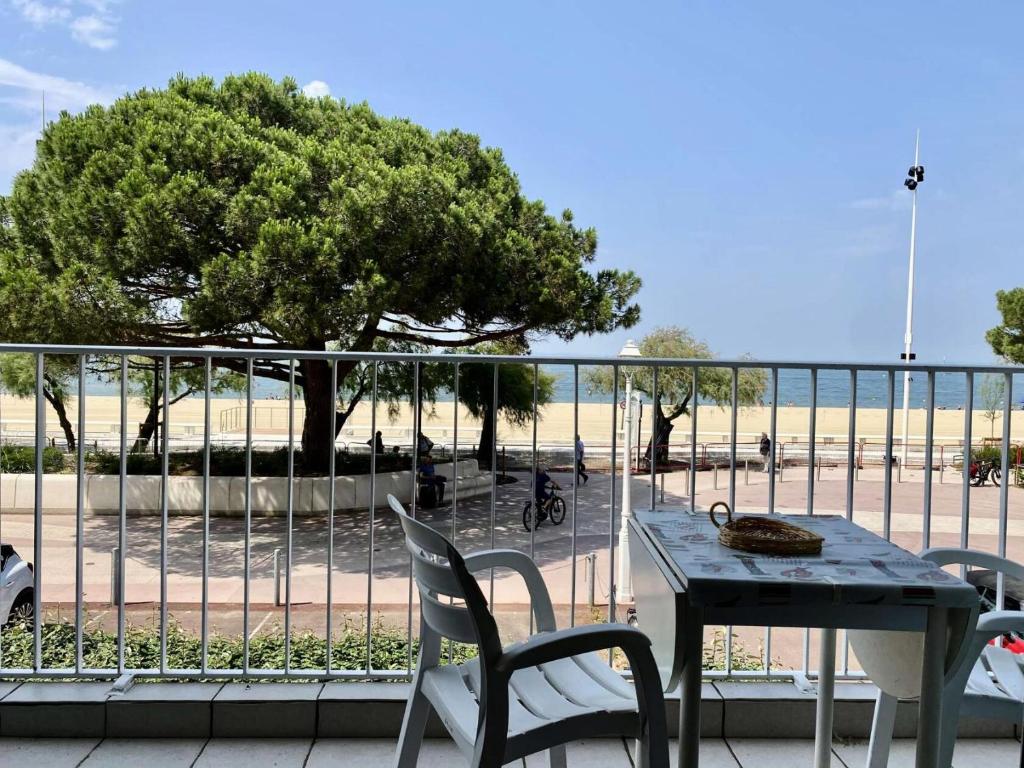 une table et des chaises sur un balcon avec un arbre dans l'établissement Résidence Mogador - Arcachon - T1 avec balcon et vue mer MAE-7071, à Arcachon
