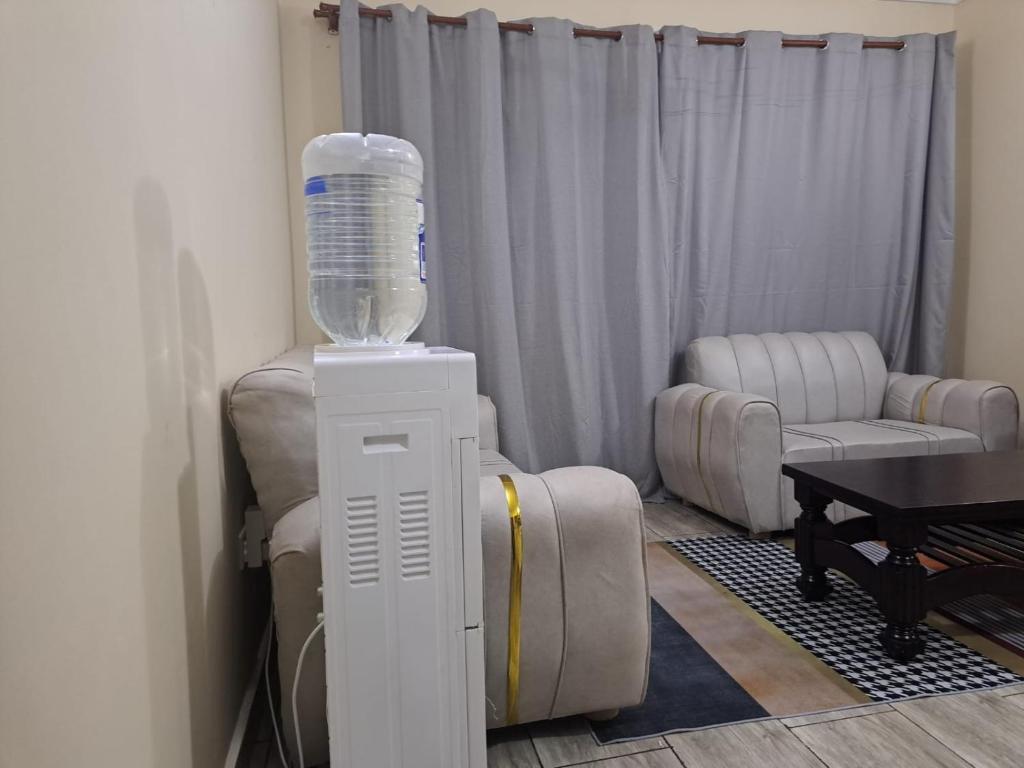 a room with a water bottle on a stand next to a chair at MJ BRACHA Holiday Vacation Home in Mombasa