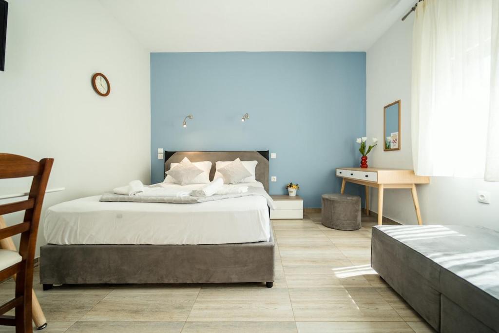 ein Schlafzimmer mit einem großen Bett und einem Schreibtisch in der Unterkunft Seaside Studio in Nea Peramos, Sleeps 4 in Néa Péramos