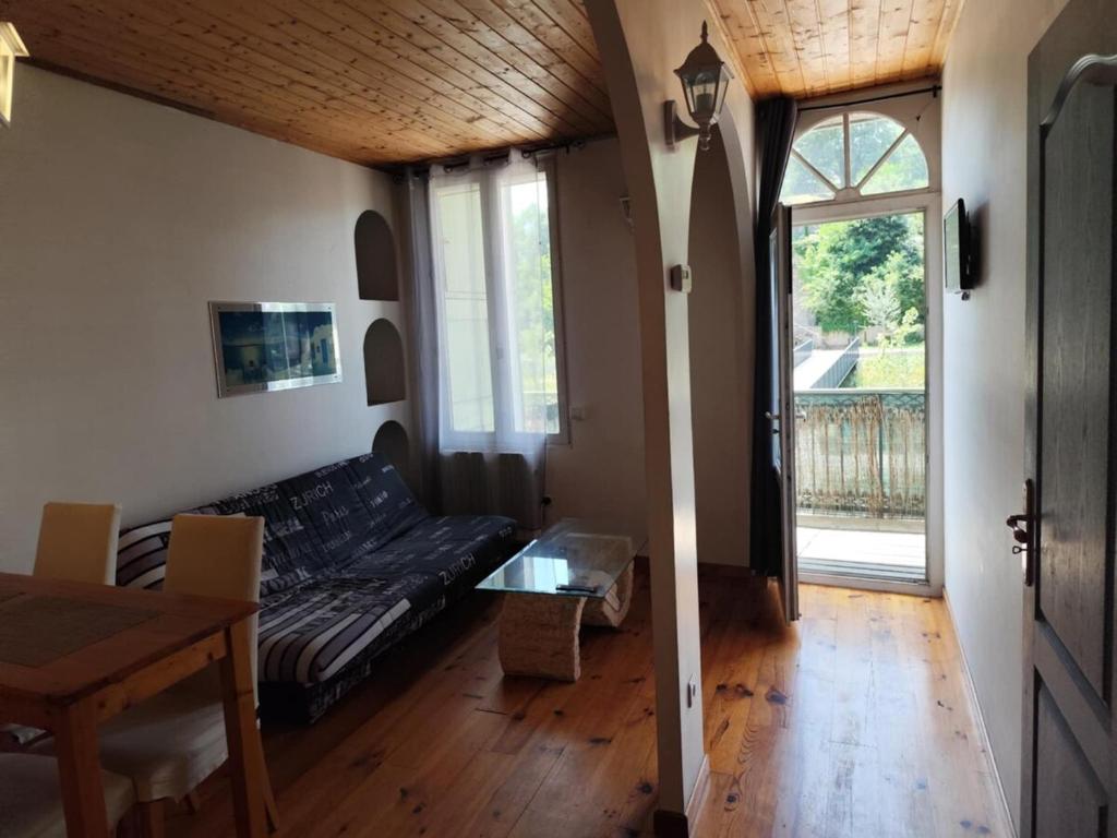 un salon avec un canapé et une table dans l'établissement le Balcon de la Savasse, à La Celle-sous-Gouzon