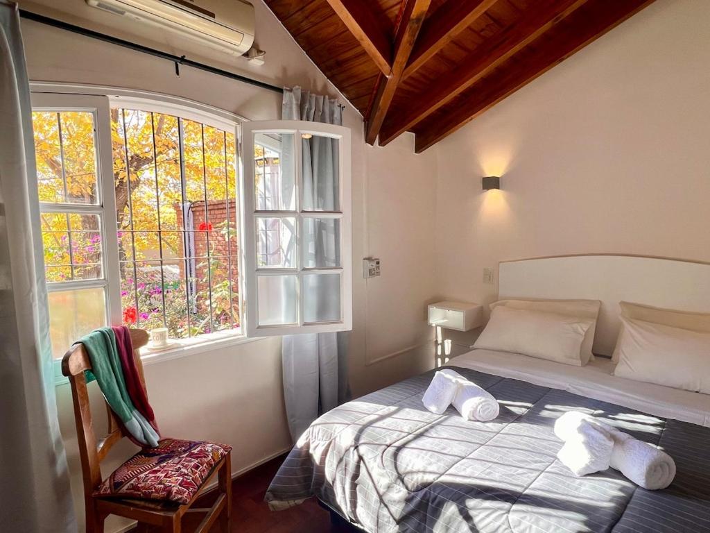a bedroom with a bed and a window at Chalet del Hijo Prodigo-wine&suites in Mendoza
