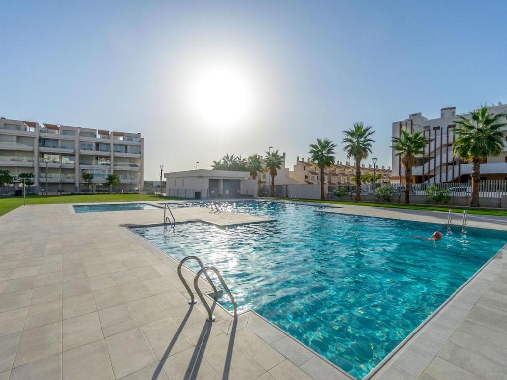 Una gran piscina con dos sillas frente a un edificio. en Ema Residencial, en Villamartin