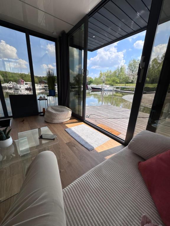 a living room with a couch and a large window at House Boat logement insolite in Deûlemont