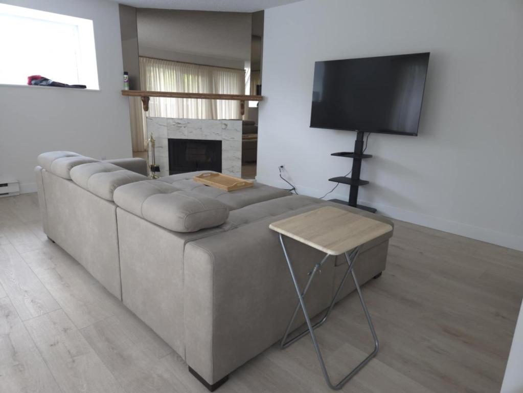 Una sala de estar con un sofá y un televisor de pantalla plana. en Fairview Townhouse, en Vancouver