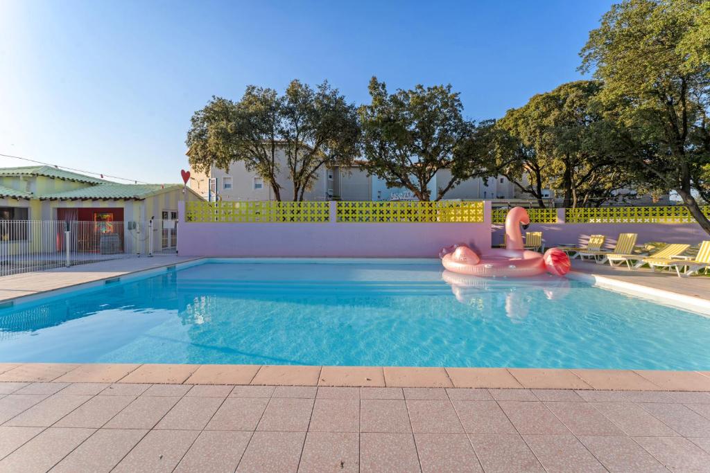 une piscine avec un radeau gonflable au milieu dans l'établissement greet hôtel Pont du Gard - Route d'Avignon, à Estézargues