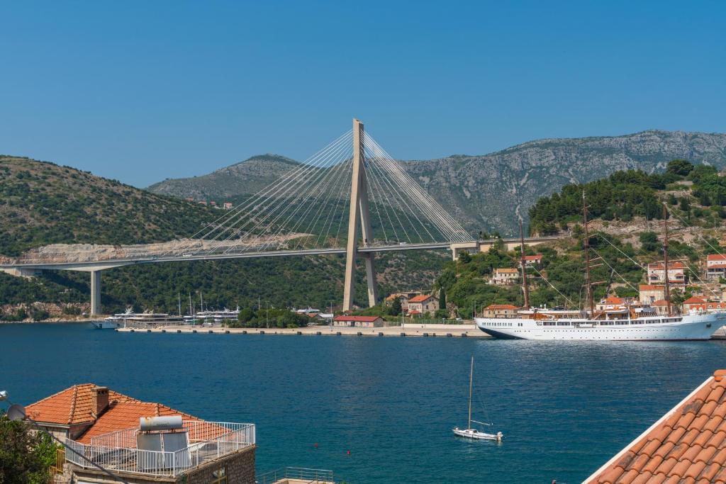 a boat in the water with a bridge in the background at APARTMENT LEA BAYVIEW in Dubrovnik