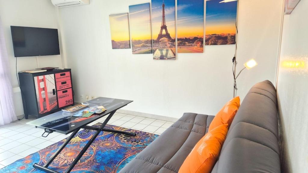 un salon avec un canapé et une table dans l'établissement Appartement 2P, balcon, parking proche mer, à Nice