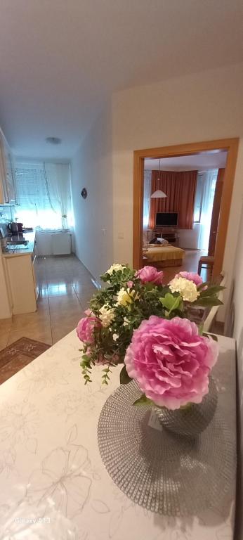 eine Vase voller rosa Blumen auf einem Tisch in der Unterkunft Favorite apartment in Hévíz