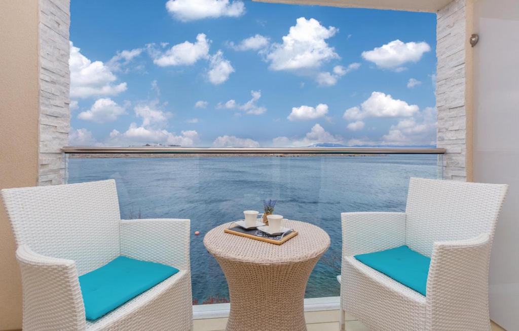 a table and chairs with a view of the ocean at MERTIK Apartment in Omišalj