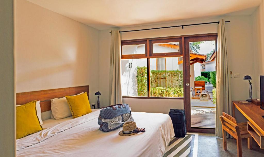 1 dormitorio con cama, escritorio y ventana en Escape Beach Resort - SHA Extra Plus Certified, en Mae Nam