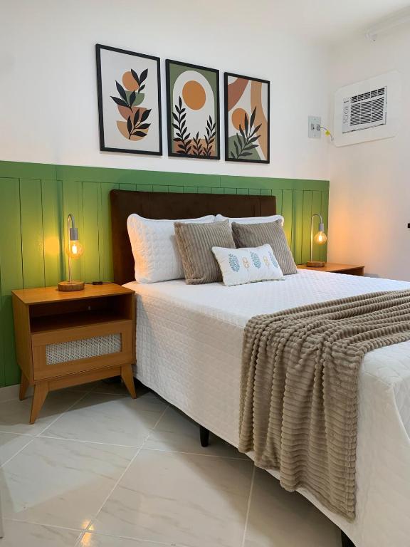 a bedroom with a large bed and a night stand at Apart Atalaia ar cond 2 qtos in Aracaju