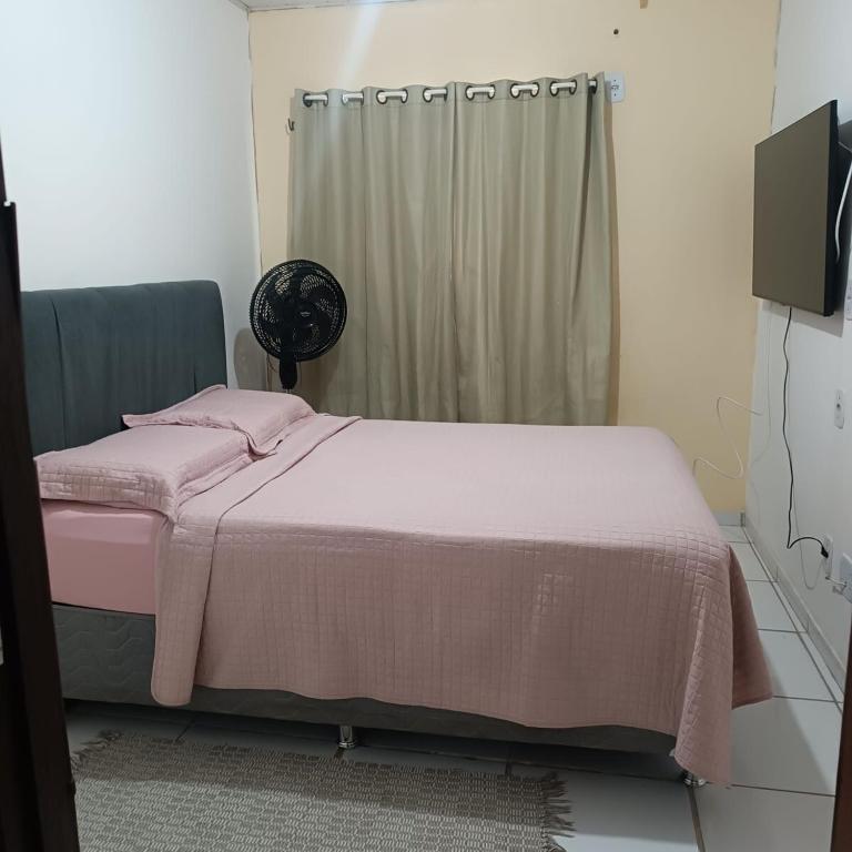a bedroom with a bed with a pink blanket at Apartamento condominiofechado in Ananindeua