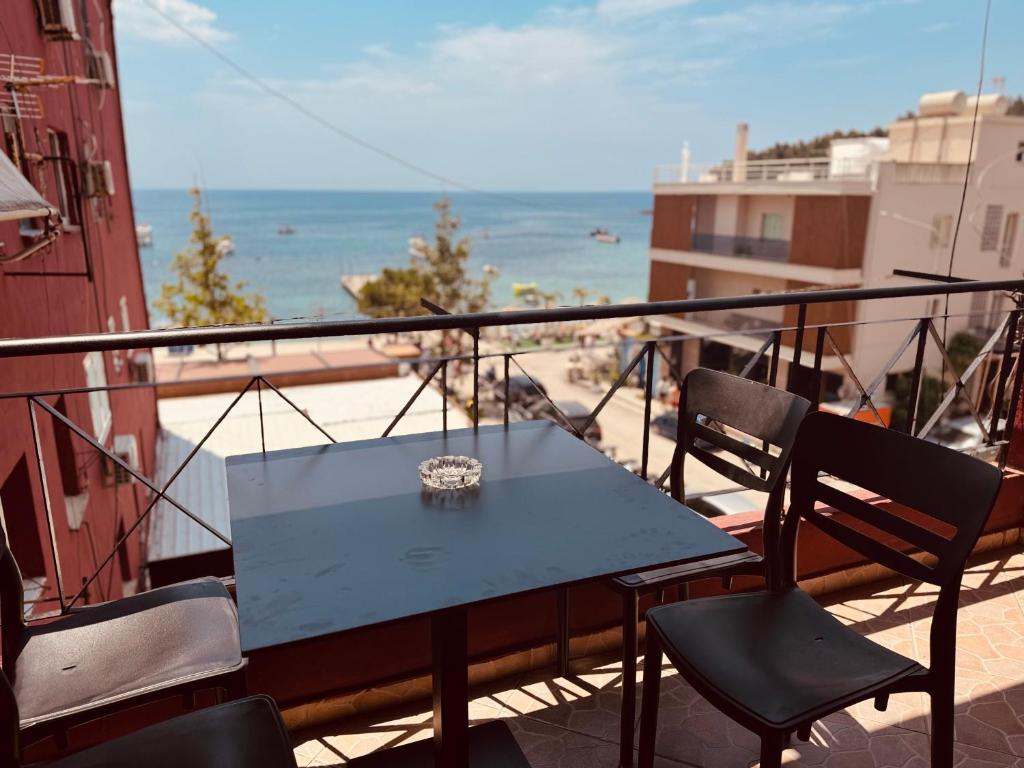 a table and chairs on a balcony with a view of the beach at RIA apartment in Himare