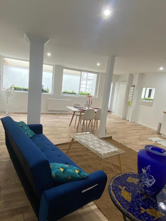 un salon avec un canapé bleu et une table dans l'établissement Appartement Cordier, à Saint-Amand-Montrond