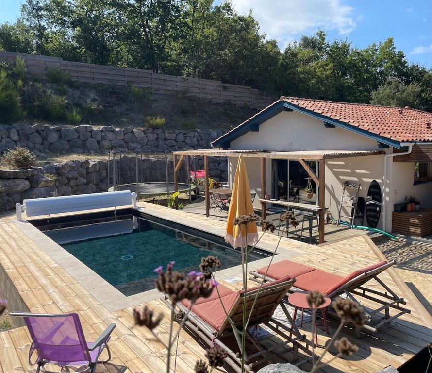 une piscine avec des chaises et une maison dans l'établissement Villa OHANA - au calme et proche des plages, idéale pour les familles, à Capbreton