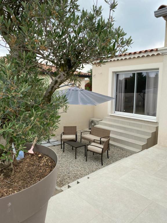 une terrasse avec 2 chaises, une table et un arbre dans l'établissement Studio pour vacances, à Monteux