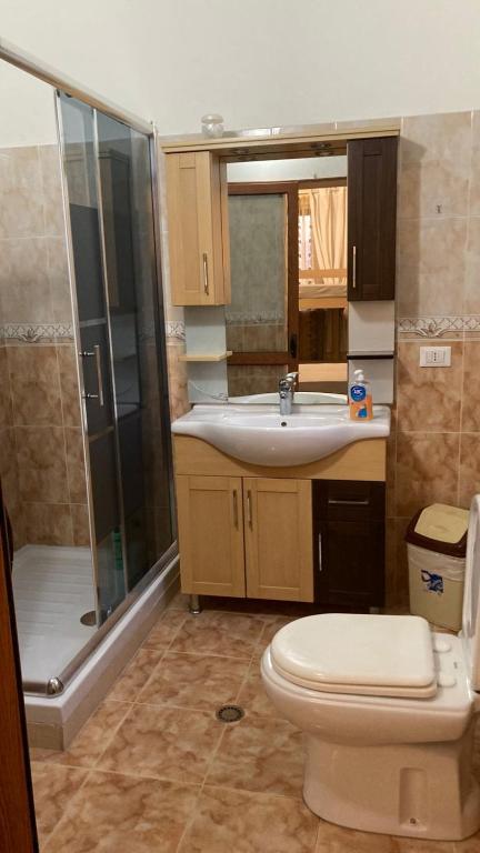 un bagno con wc, lavandino e doccia di Blissful Hostel a Shkodër
