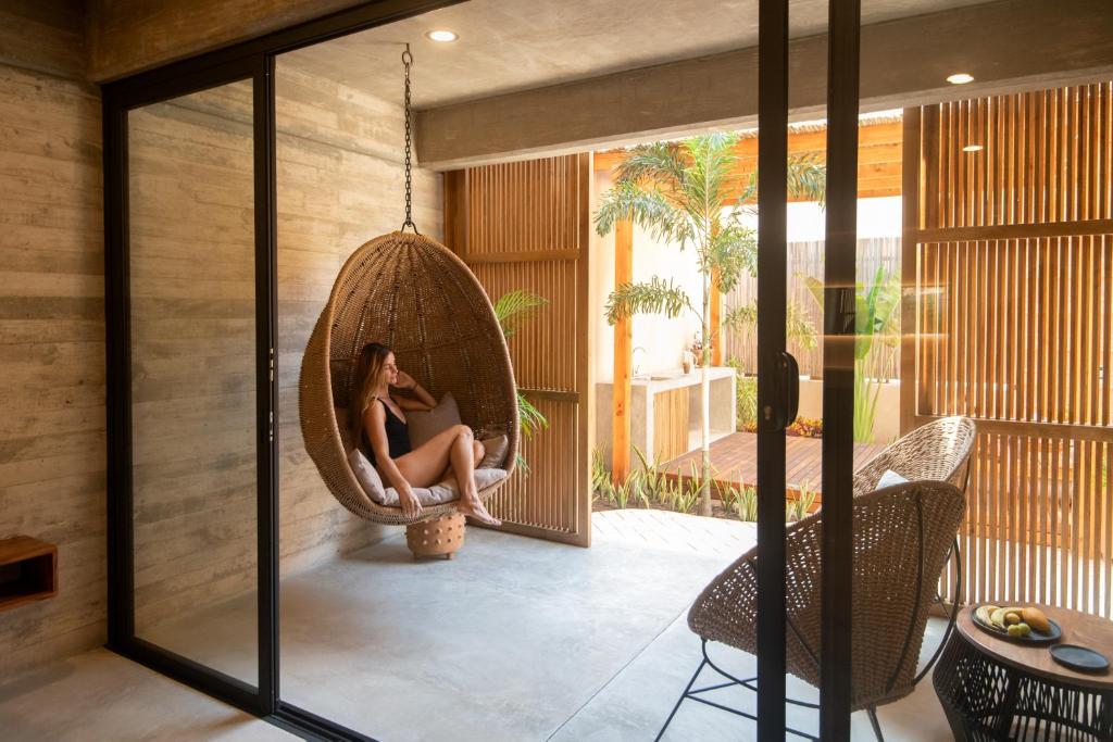 a woman sitting in a hanging chair on a patio at Jiloo- Beautiful Oasis in Punta Zicatela 7 in Brisas de Zicatela