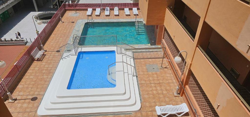 Una vista aérea de una piscina en un edificio. en Edén Los Cristianos, en Los Cristianos
