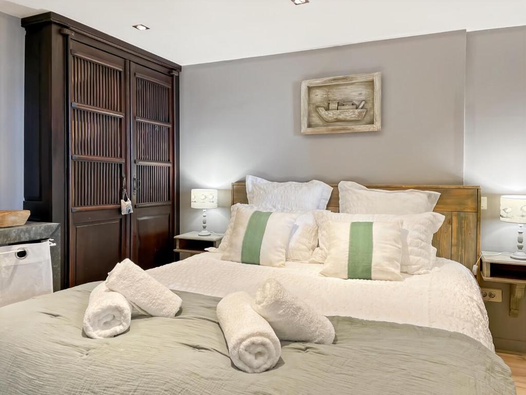une chambre avec un grand lit avec des serviettes dessus dans l'établissement Nous y Somme, bel appartement face à la Baie, à Saint-Valery-sur-Somme