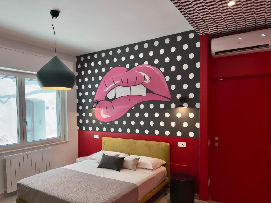 a bedroom with a painting of a mouth on the wall at Emily in Wonderland in Nardò