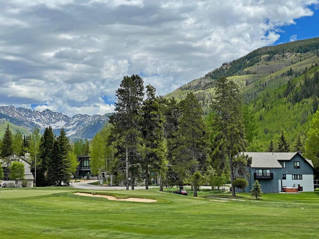 a golf course with a house and mountains in the background at Private Hot Tub and Sauna, Right on Fairway, Minutes From Vail Village & Golden Peak in Vail