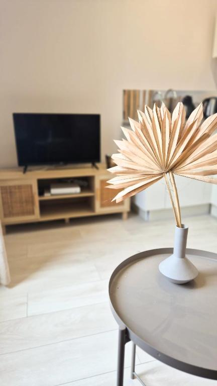 une table avec une fleur dans un salon dans l'établissement Appartement cosy, climatisation, proche mer, à Nice