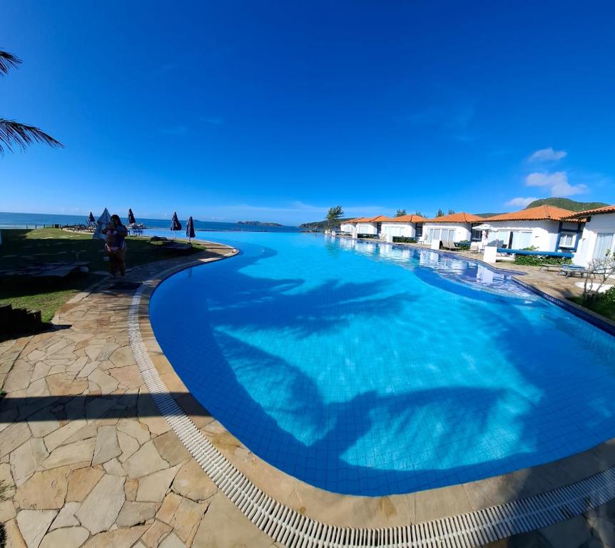 a large swimming pool next to a beach at Búzios Beach Resort in Buzios