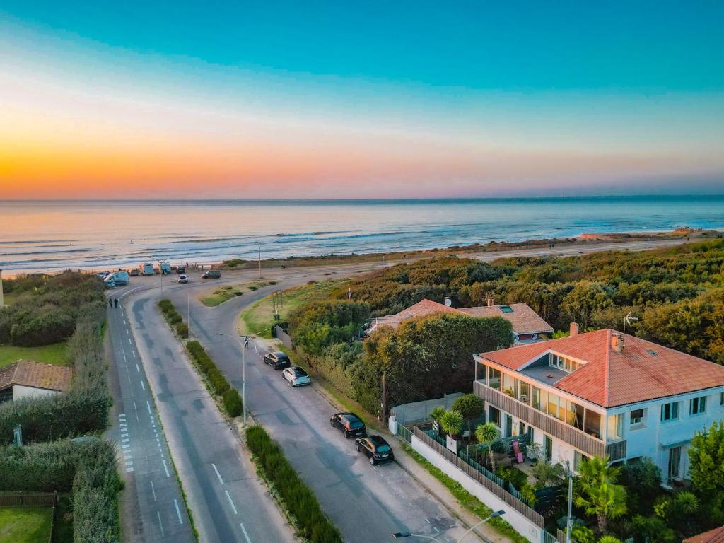 - une vue aérienne sur une maison et l'océan dans l'établissement Appartement phare, à Soulac-sur-Mer