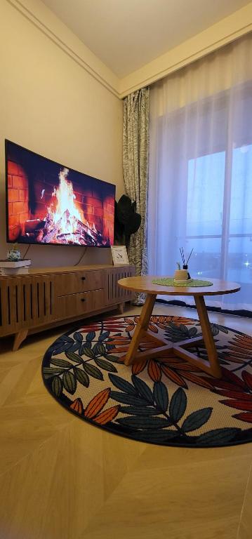 a living room with a large tv and a table at Acquila Crest by JKIA in Nairobi