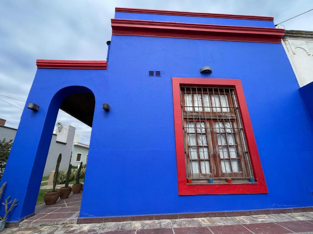 a blue and red building with a red window at Villa Tequila-Casa Frida in Alta Gracia