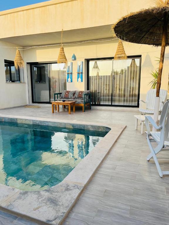 a house with a swimming pool and a patio at Dar Ayla à DJERBA houmt souk in Houmt Souk