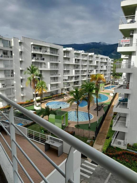 a view of a hotel with two pools and palm trees at Apartamento alto verde in Melgar