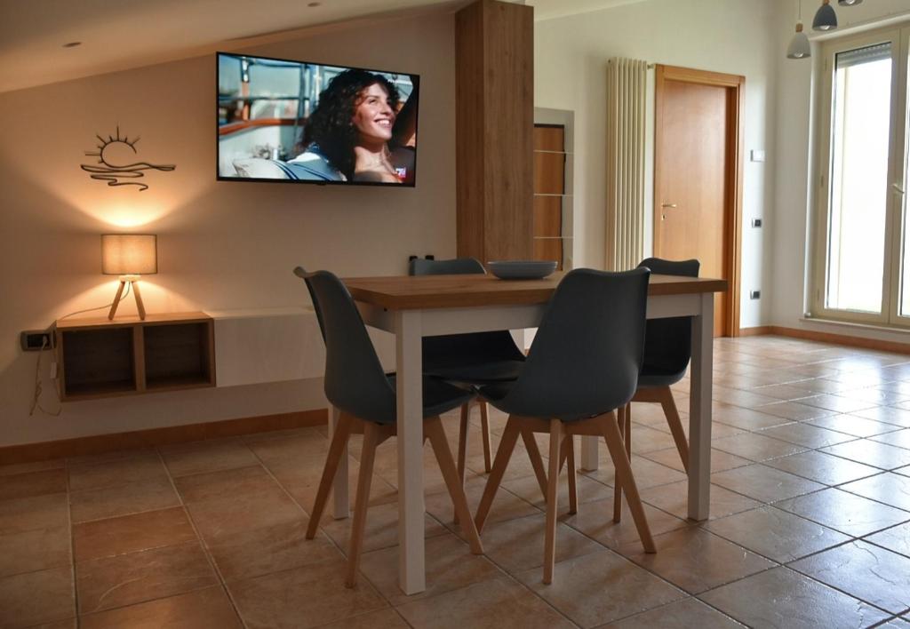 ein Esszimmer mit einem Tisch und Stühlen sowie einem TV an der Wand in der Unterkunft Terrazza Sole e Stelle in Matera