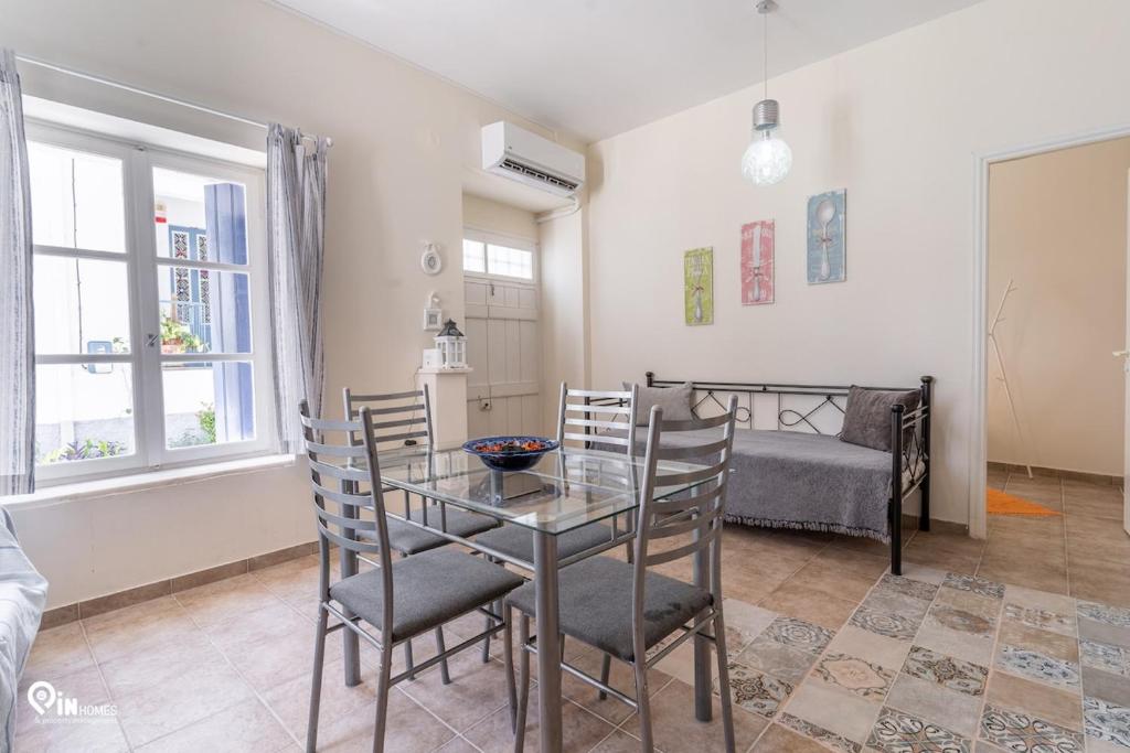 a dining room with a table and chairs and a bed at Omiros - Spacious Seaside House At Poros in Poros
