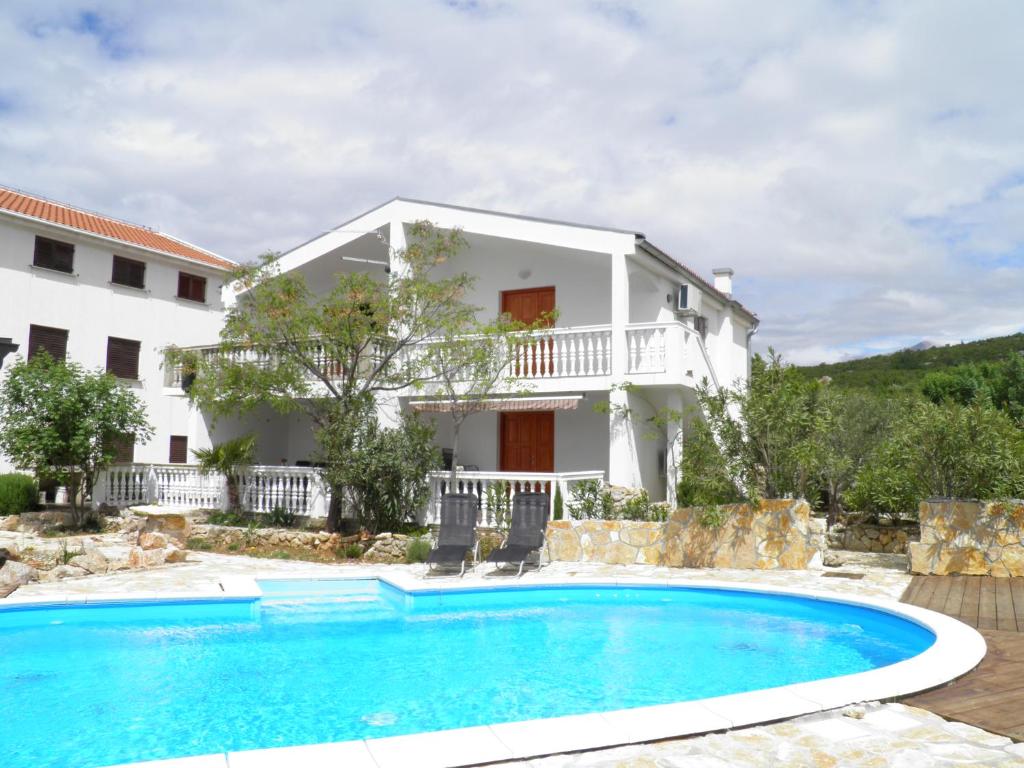 Villa con piscina frente a una casa en Apartments Zen, en Maslenica