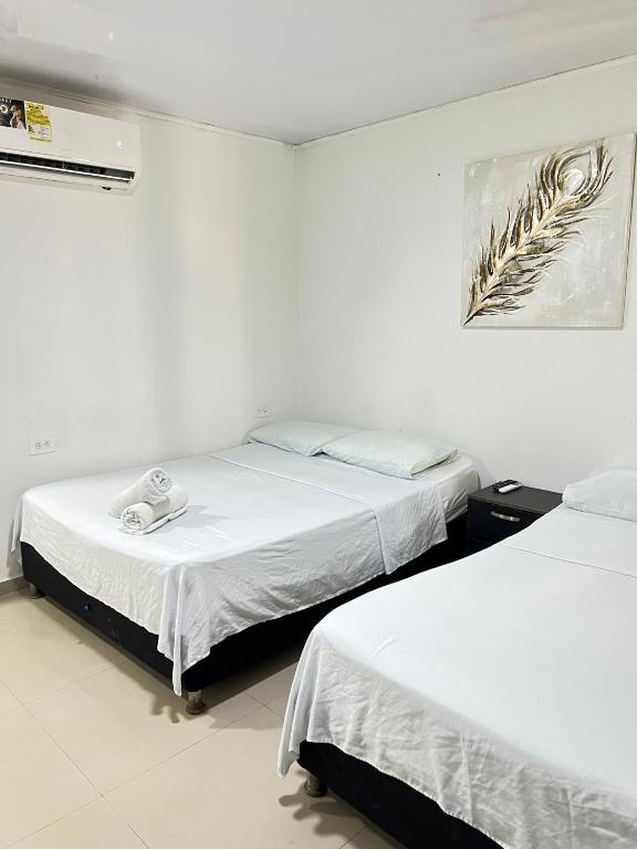 2 camas en una habitación con paredes blancas en Tropical Dreams, en San Andrés