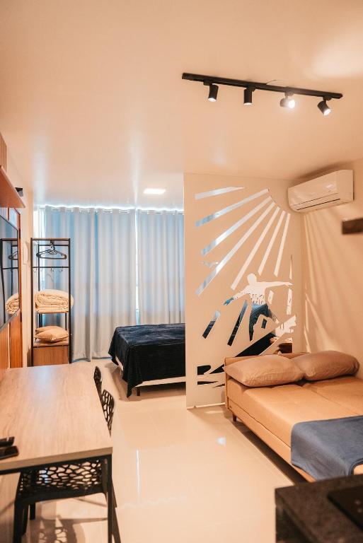 a living room with two beds and a table at LOFT Sofisticado na Praia de Vila - Centro in Saquarema