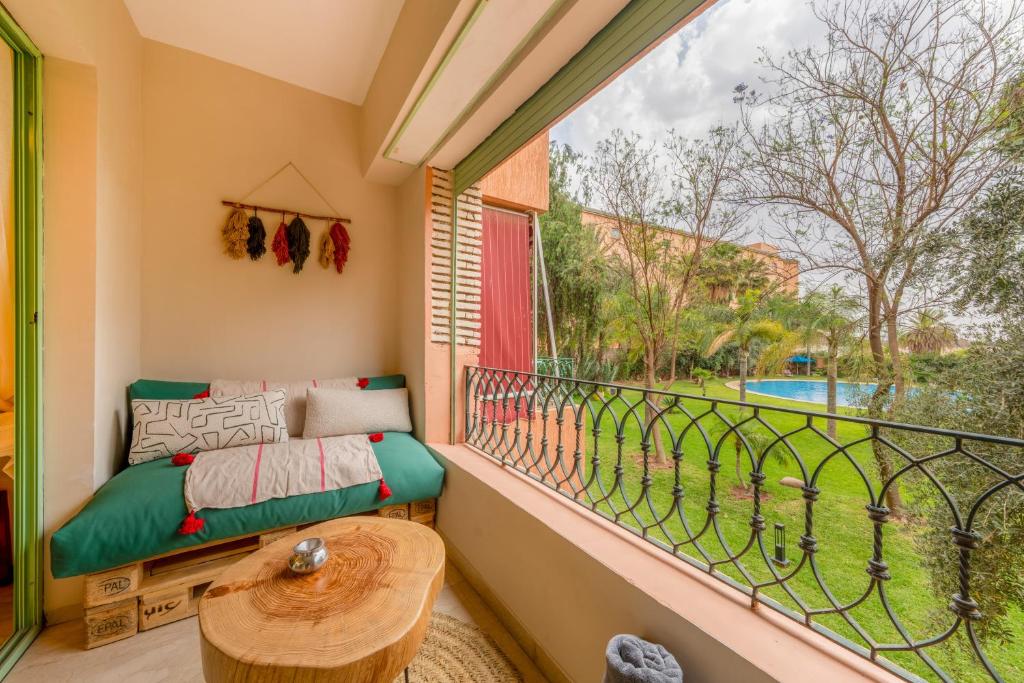 a balcony with a couch and a table and a window at Babylone Appart & Pool, Hivernage in Marrakech