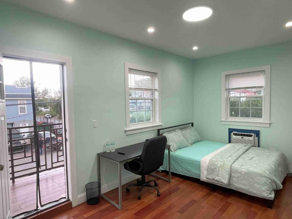 a bedroom with a bed and a desk and windows at Near JFK-Private room with share bath and Kitchen in Brooklyn