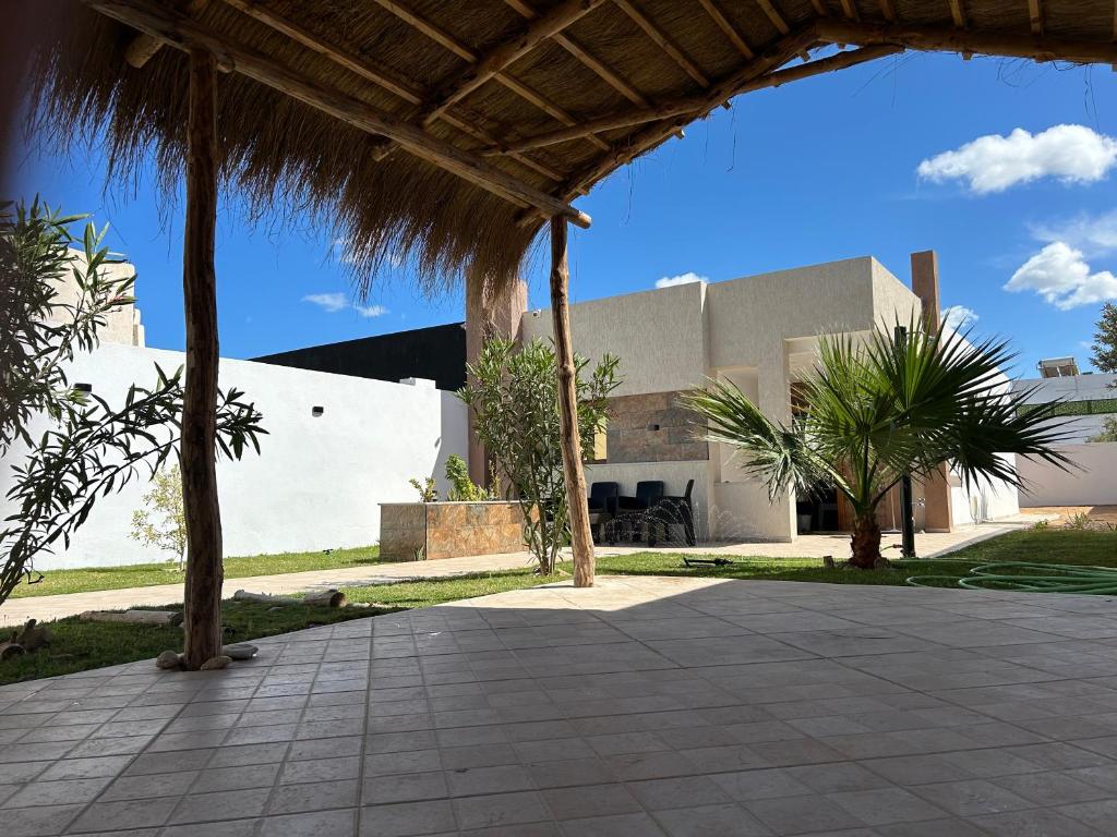 Al MaqārisahにあるDjerba Hausのヤシの木とパティオのある建物の景色を望めます。