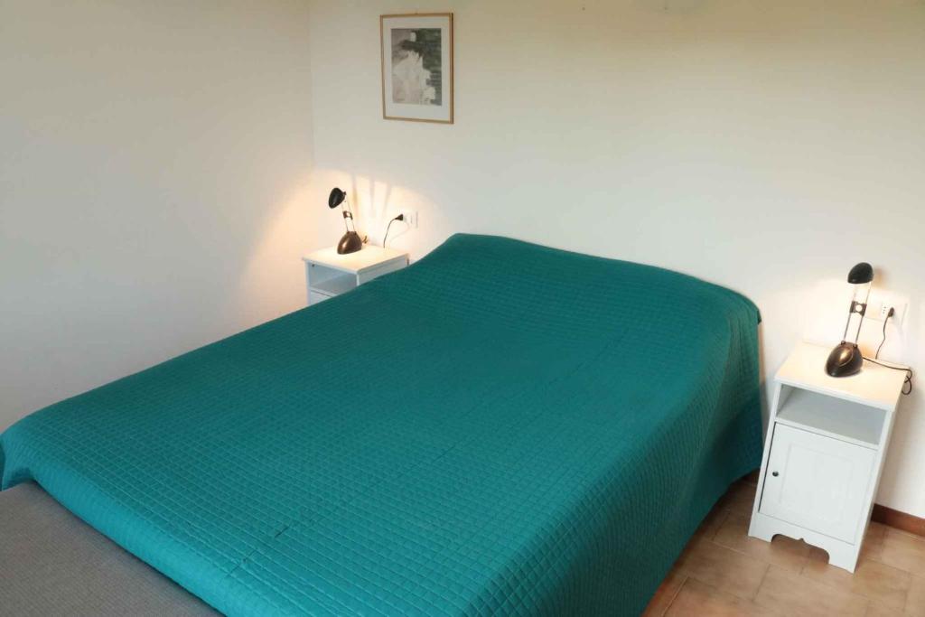 sypialnia z zielonym łóżkiem i 2 stolikami nocnymi w obiekcie Studio in Lazise/Gardasee 21938 w mieście Lazise